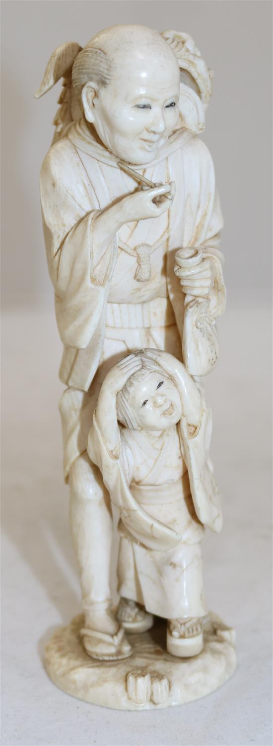 A Japanese ivory group of a shi-shi dancer and a boy, Meiji period, 17.5cm